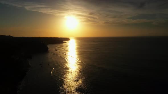 Blurry Golden Sunset Reflects on Calm Dark Ocean Surface