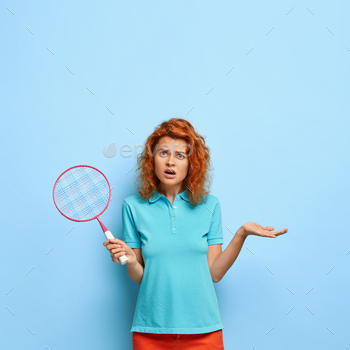 acket, gestures with displeasure, lose game, has argument with opponent, dressed casually, poses against blue studio wall, expresses negative emotions