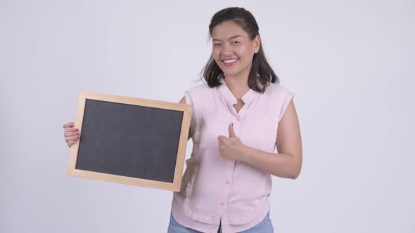 Young Happy Asian Businesswoman Holding Blackboard and Giving Thumbs Up