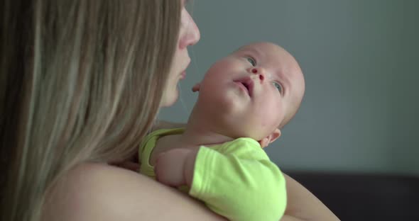 Happy Mother Holds Her Baby on Hands and Kisses