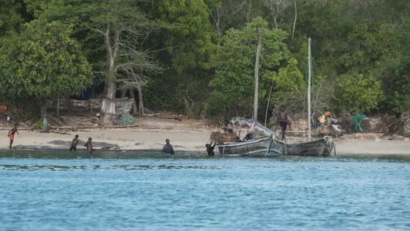 Local African Fishing Village Locals Unload the Dhow Fishing Boat Off the Coast