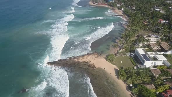 White Foaming Ocean Waves Roll on Sandy Coastline Aerial