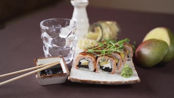 The camera moves away from the sushi set beautifully decorated on a plate