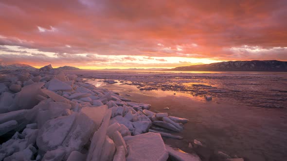 Colorful sunset timelapse over stacks of ice on Utah Lake