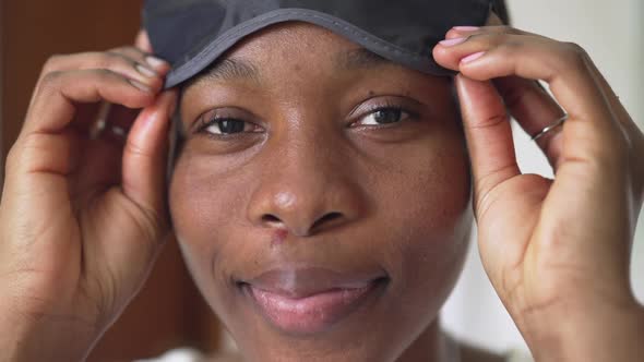 Headshot African American Woman Taking Off Sleeping Eye Mask Smiling Looking at Camera