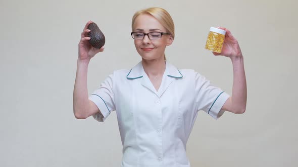 Nutritionist Doctor Holding Organic Avocado Fruit and Jar of Medicine or Vitamin or Omega 3 Capsules