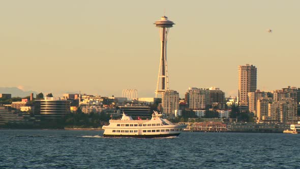 Sunset at Elliot Bay in Seattle with ferry crossing in front of the Space Needle.