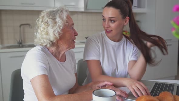 Woman Helping Grandmother with Laptop