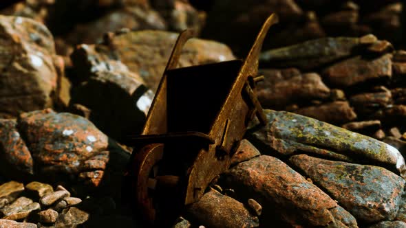 Abandoned Wooden Mine Wheelbarrow on Rocks