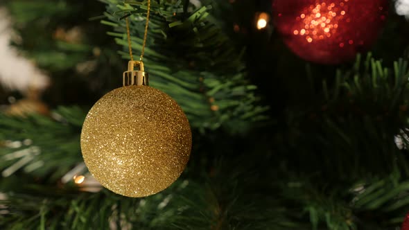 Golden sparkling bauble on the branch 4K 2160p 30fps UltraHD footage - Decorative   ornament hanged 