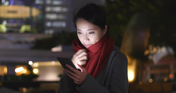 Young Woman use of smart phone in city at night