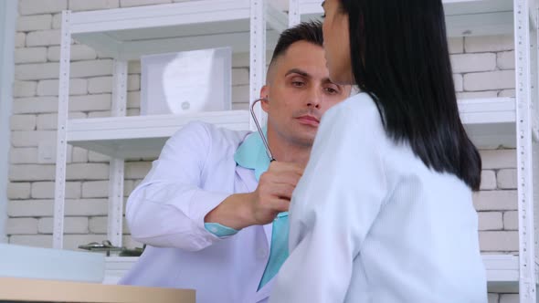 Doctor in Professional Uniform Examining Patient at Hospital