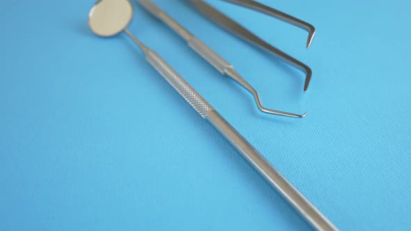 Dentist Metal Medical Tools on Blue Background