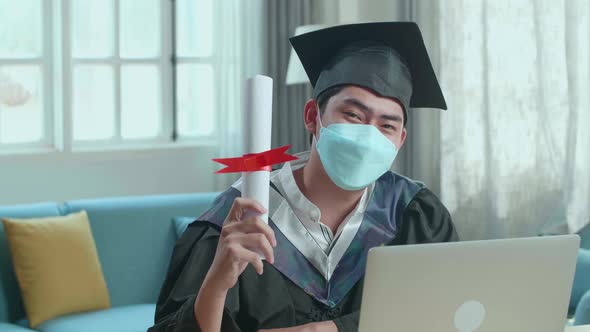 Excited Man Wearing Protection Face Mask And Holding A University Certificate, Smiling To Camera alt