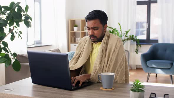 Sick Man with Laptop Drinking Tea and Coughing