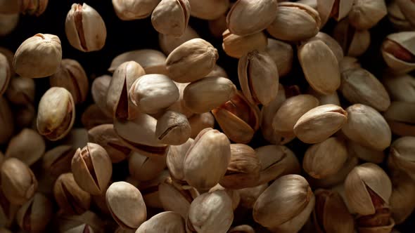 Super Slow Motion Shot of Pistachios Flies After Being Exploded Against Black Background 1000Fps