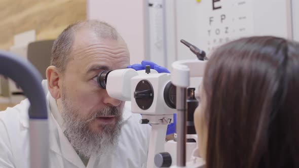 Senior Optometrist Checking Eyes of Patient with Slit Lamp Biomicroscope