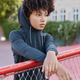 Vertical shot of thoughtful teenager dressed in stylish hoodie and