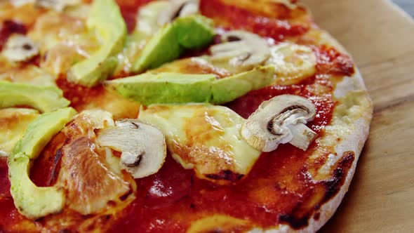 Baked pizza with avocado and mushroom toppings