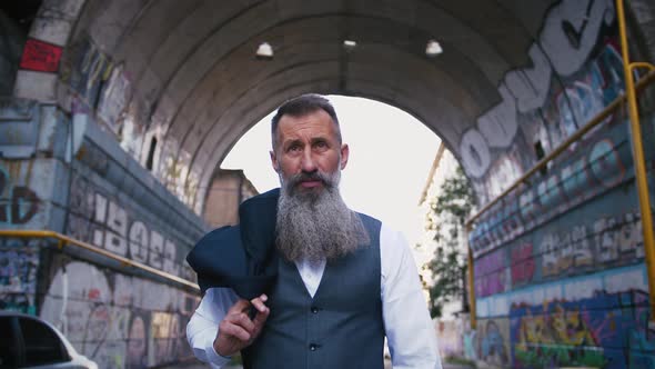 Handsome Bearded Mature Man in Suit Walking Outdoors in City with Graffiti Background Slow Motion