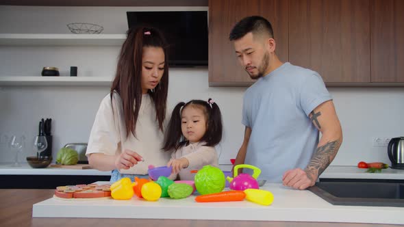 Caring Asian Parents and Cute Baby Girl Playing Educational Game