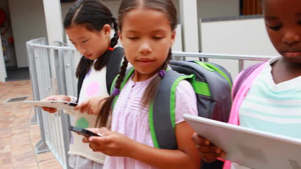 Group of school kids using digital tablet and mobile phone