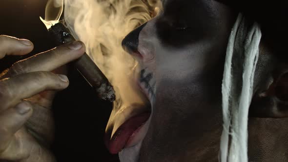 Frightening Man in Skeleton Halloween Cosplay Costume Smoking Cigar, Making Faces, Showing Tongue