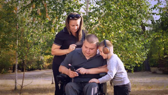 Wheelchair Man. Handicapped Man. Young Disabled Man Sits in Wheelchair, Surrounded By His Family