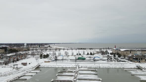 Drone view with Lake Michigan in the background. Gray sky of winter with snow and ice on the water.