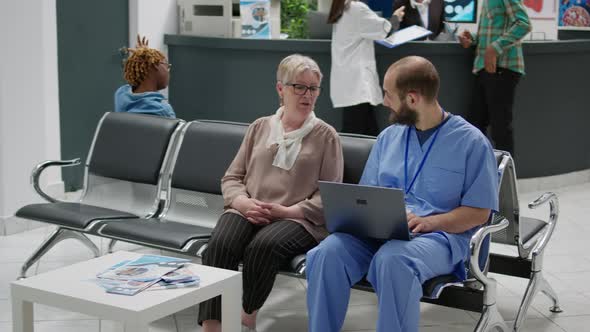 Senior Woman and Medical Assistant Looking at Laptop