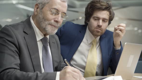 Grey-haired Customer in Glasses Signing Contract