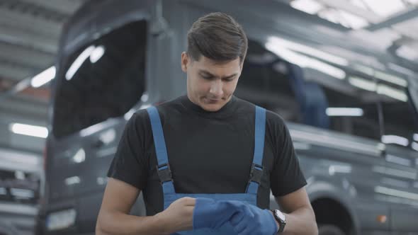 Portrait of Handsome Caucasian Man Walking in Slow Motion and Taking Off Working Gloves