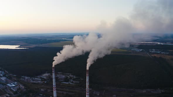 View of pipes with smoke. Power plant with white smoke over blue sky