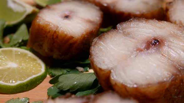 Smoked Eel with Lime Slices Are Lying on a Board 