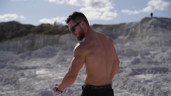 Shirtless young bodybuilder posing on nature