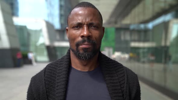 Adult Serious Black Man Is Walking in Business District in Downtown, Medium Portrait