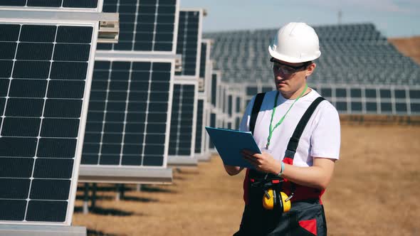 Male Engineer Is Checking Solar Batteries. Renewable Energy, Solar Plant, Green Electricity Concept