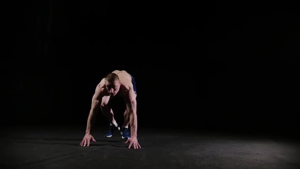 A Young Sports Man Doing a Backflip and Doing a Push Up  Endirance Training in Black Studio