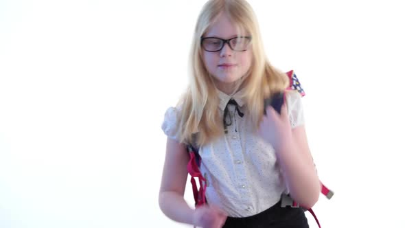 Beautiful Schoolgirl with a School Backpack and Wearing Glasses Posing in the Studio on a White