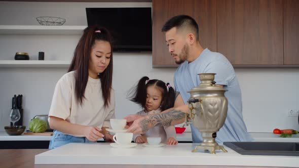 Asian Family Tea Drinking at Home Using Vintage Samovar