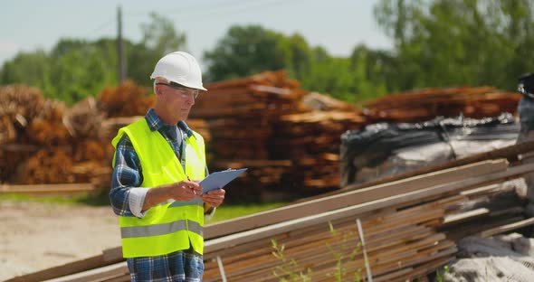 Male Worker Examining Plank's Stack