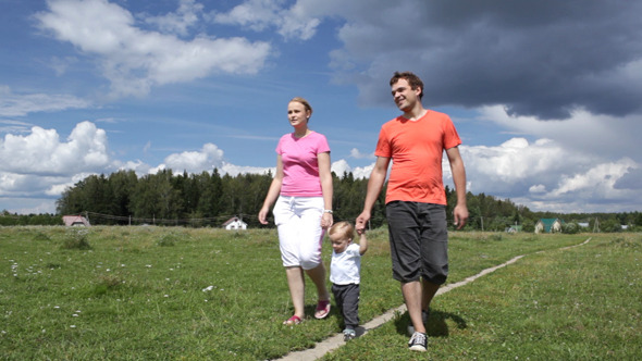 Young Family Of Three Walking Outdoors