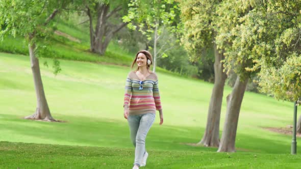 People in Green Park at Summer Happy Smiling Woman Jumping and Listening Music