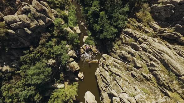 Panoramic View of in Riverbed with Rocky Riversides and Big Boulders with Swimming People