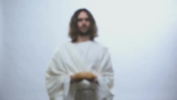 Jesus Holding Bread on Illuminated Background, Sacramental Food in Religions