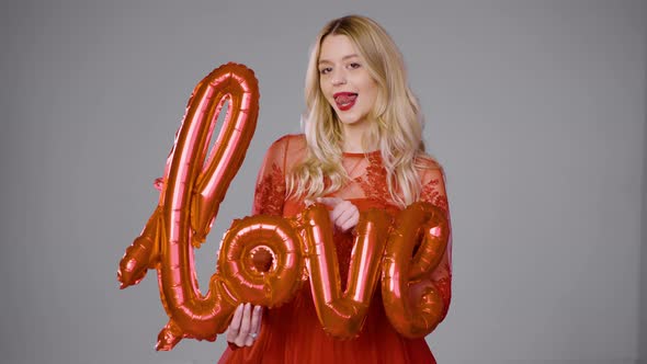 Delighted Woman Playing with Air Balloon in Studio