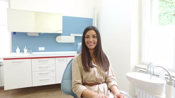 Smiling woman looking at camera while sitting in the dental chair