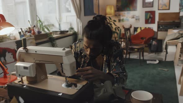 Indian Dressmaker Working on Sewing Machine in Atelier