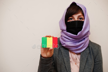 , protect face mask and hijab head scarf, hold Mali flag card against isolated background. Coronavirus country concept.