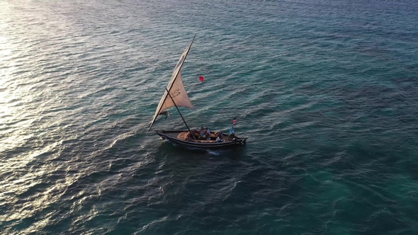 Colorful sunset above the sea surface with sail boats, aerial view Zanzibar.